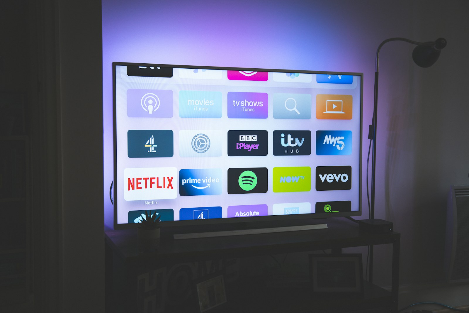 Wall-mounted television with soft ambient backlighting in a living room